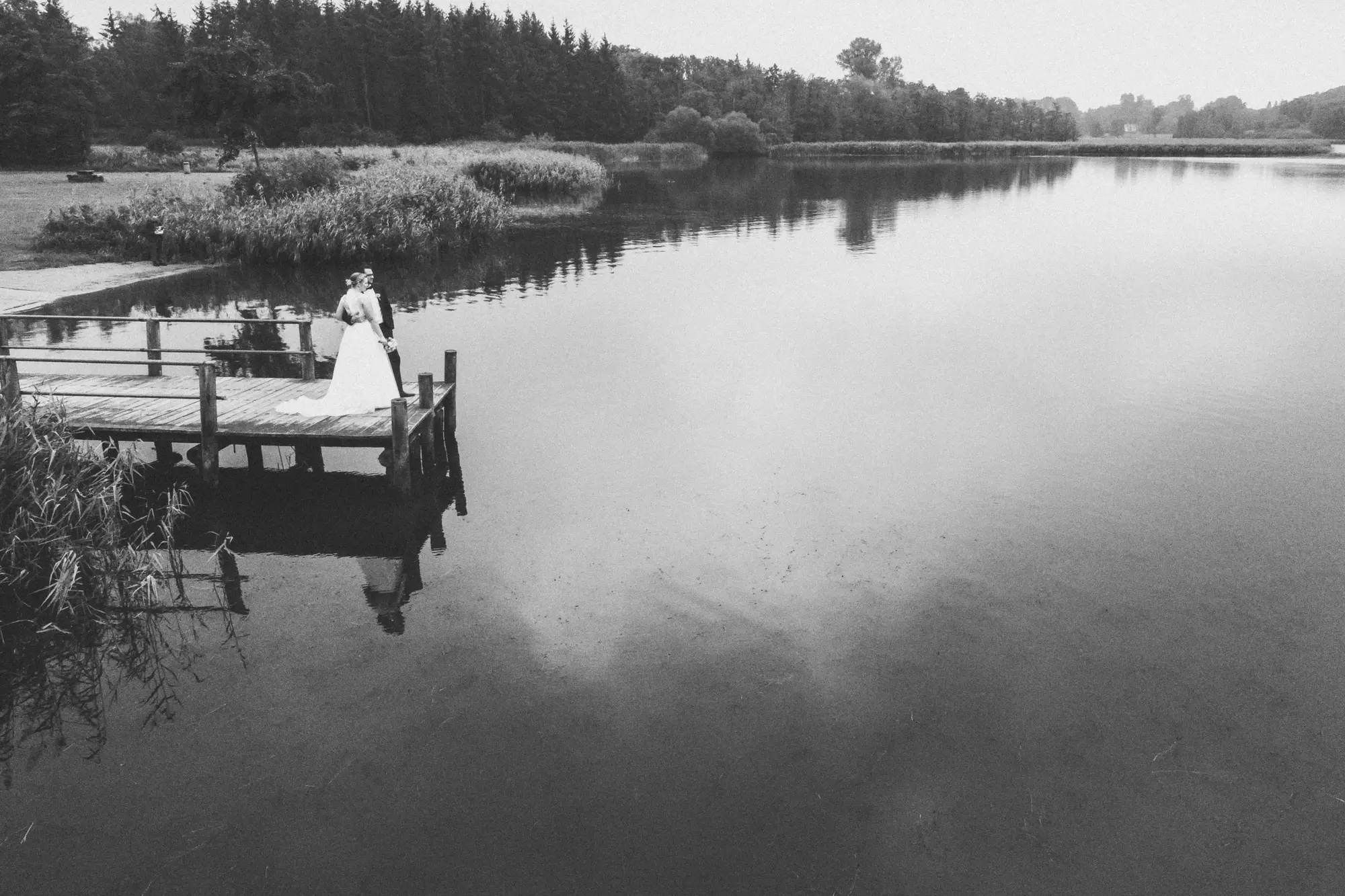 Brautpaar auf Steg am See
